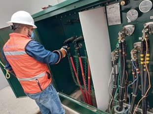 Técnico realizando mantenimiento y pruebas en equipo eléctrico